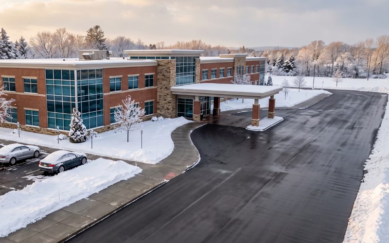 Cleared drop-off lane and entry walkway at a medical office building