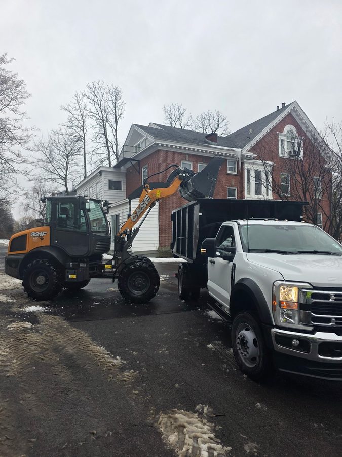 Loader lifting a snow bank into a dump truck